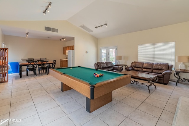 rec room with track lighting, light tile patterned floors, lofted ceiling, and visible vents