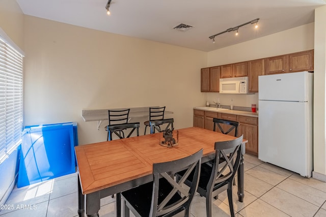 dining room with light tile patterned floors, track lighting, and visible vents