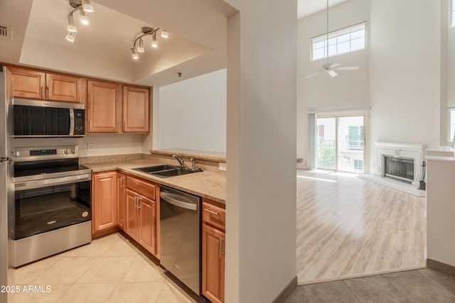 kitchen with ceiling fan, a sink, light countertops, stainless steel appliances, and light tile patterned flooring