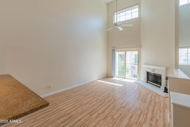 unfurnished living room featuring a fireplace, a wealth of natural light, and light wood-type flooring