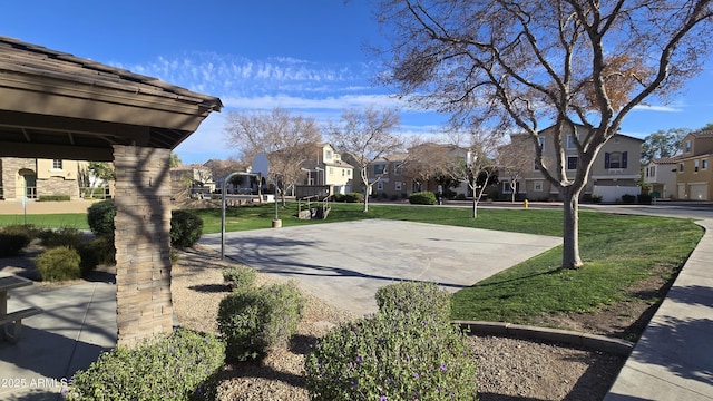 view of sport court featuring community basketball court, a residential view, and a yard