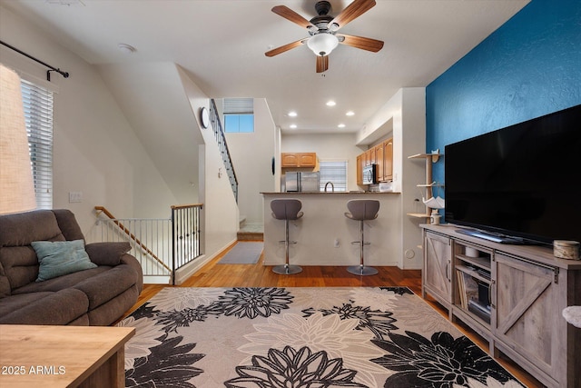 living area featuring a ceiling fan, recessed lighting, and light wood-style flooring