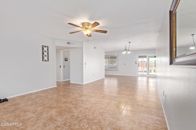 unfurnished room with ceiling fan with notable chandelier and light tile patterned floors