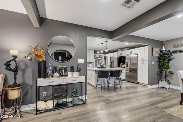 3207 N Steves Blvd, Flagstaff, AZ 86004 - bar with stainless steel fridge, visible vents, baseboards, beamed ceiling, and light wood-style floors