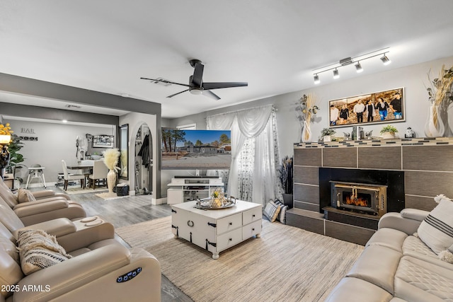 3207 N Steves Blvd, Flagstaff, AZ 86004 - living room with a ceiling fan, a tiled fireplace, and wood finished floors
