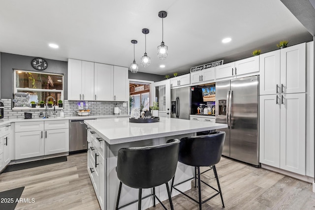 3207 N Steves Blvd, Flagstaff, AZ 86004 - kitchen with white cabinets, light wood-type flooring, appliances with stainless steel finishes, and light countertops
