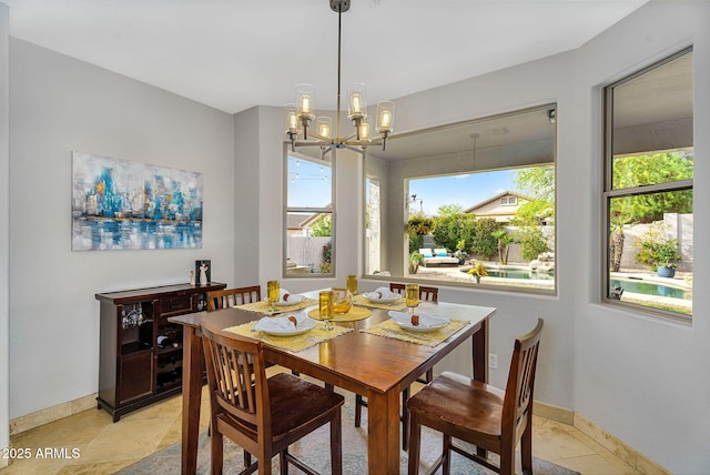 dining room featuring baseboards and a chandelier