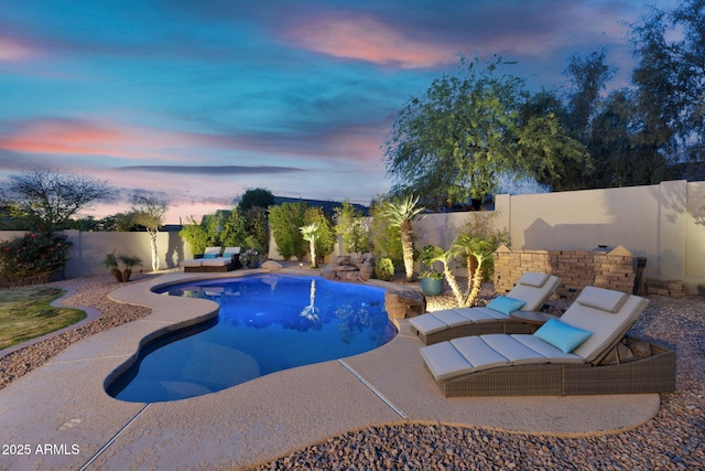 pool at dusk with a fenced backyard, a fenced in pool, an outdoor living space, and a patio area