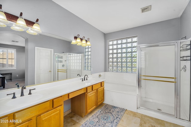 bathroom with a stall shower, a sink, and a healthy amount of sunlight