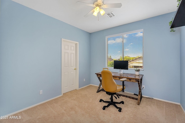 office space with baseboards, visible vents, a ceiling fan, and light colored carpet
