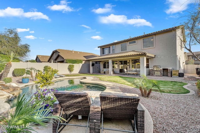 rear view of property with a fenced in pool, stucco siding, area for grilling, a fenced backyard, and a patio