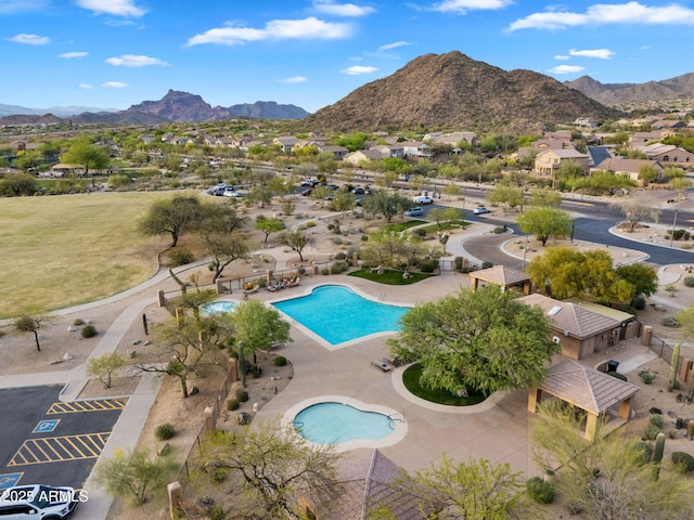 community pool with a patio and a mountain view