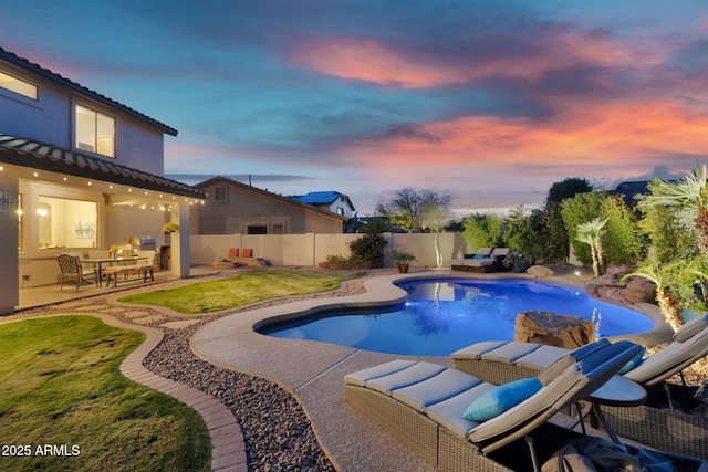 pool at dusk featuring a fenced backyard, a fenced in pool, and a patio