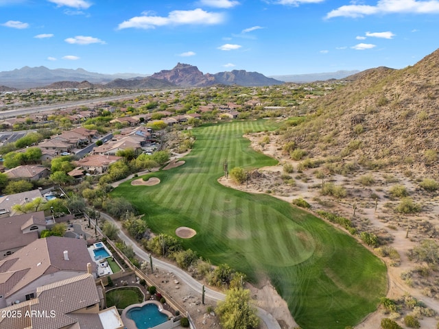 drone / aerial view with golf course view and a mountain view