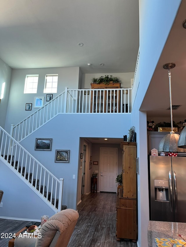 staircase featuring a high ceiling and hardwood / wood-style flooring