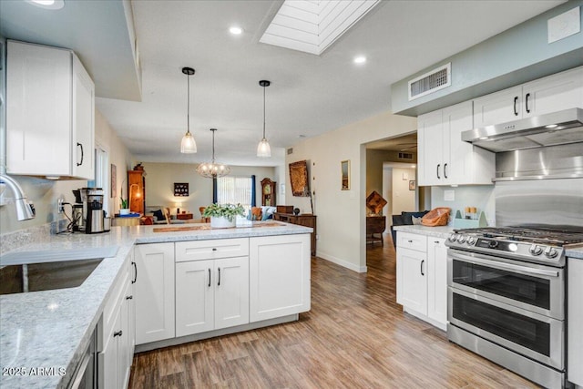 2846 E Lupine Ave, Phoenix, AZ 85028 - kitchen with a peninsula, light wood-style floors, under cabinet range hood, a sink, and double oven range