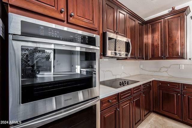 kitchen featuring appliances with stainless steel finishes, tasteful backsplash, and light tile patterned floors