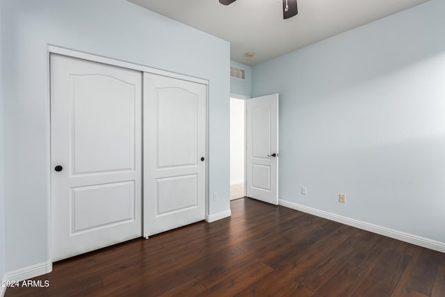 unfurnished bedroom featuring ceiling fan, dark hardwood / wood-style flooring, and a closet