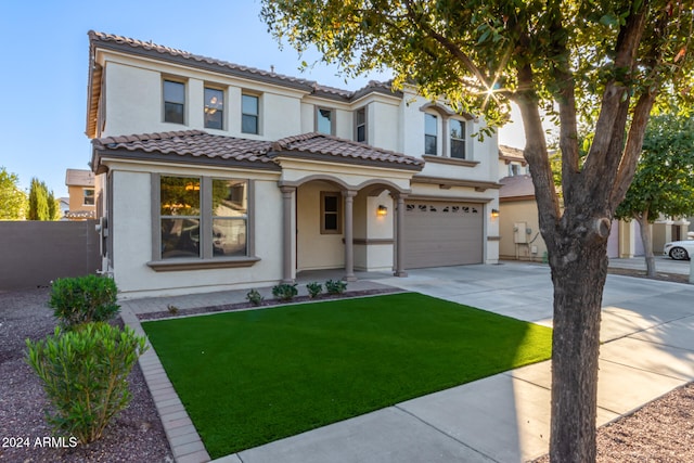 mediterranean / spanish house with a front yard and a garage