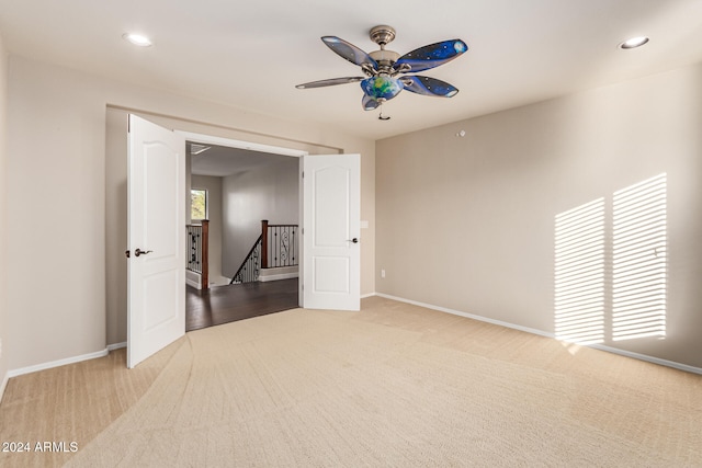 unfurnished room featuring ceiling fan and carpet floors