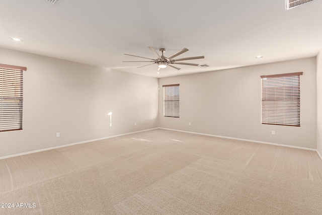 unfurnished room with light colored carpet and ceiling fan