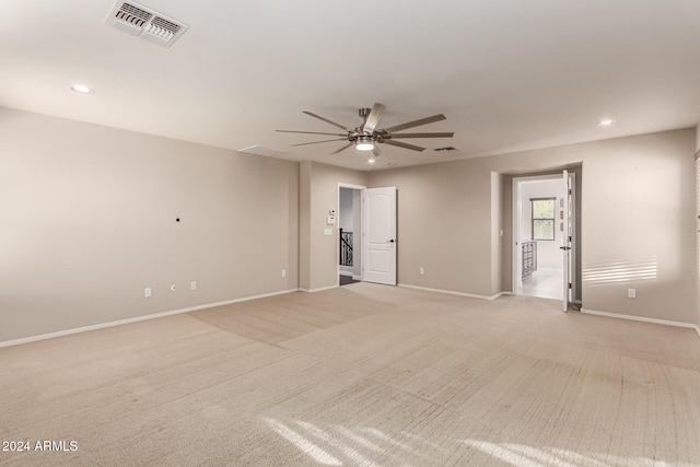 spare room with light colored carpet and ceiling fan