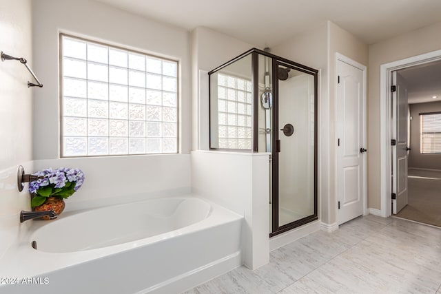 bathroom featuring separate shower and tub and a healthy amount of sunlight