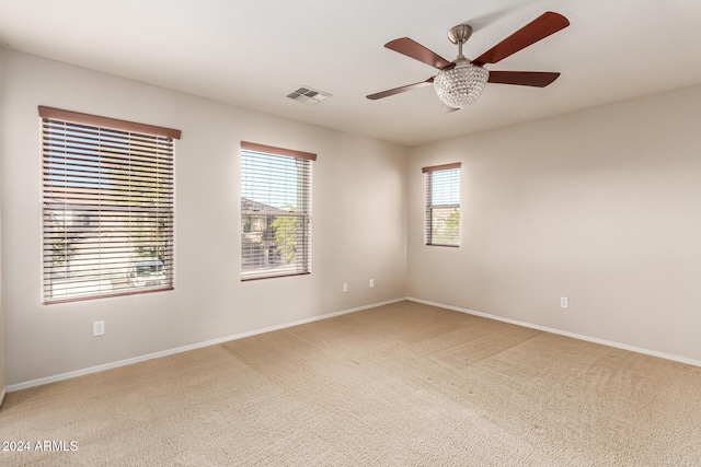 spare room featuring carpet flooring, a wealth of natural light, and ceiling fan