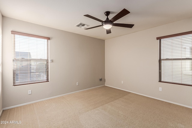 empty room featuring ceiling fan and light colored carpet