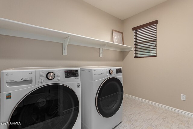 laundry area featuring washer and dryer and light wood-type flooring