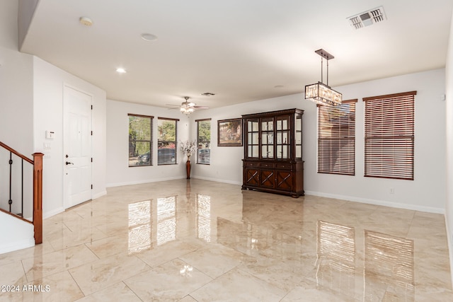 entryway featuring ceiling fan with notable chandelier