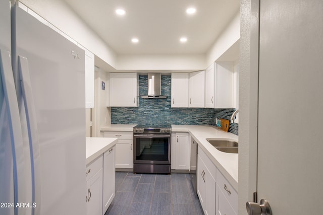 kitchen with white cabinetry, sink, wall chimney range hood, decorative backsplash, and appliances with stainless steel finishes