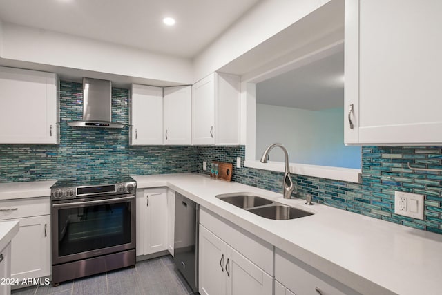 kitchen with white cabinetry, sink, wall chimney exhaust hood, tasteful backsplash, and appliances with stainless steel finishes