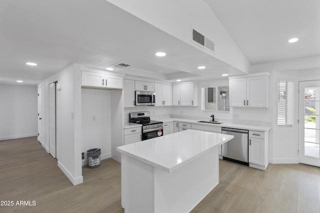 kitchen with white cabinetry, appliances with stainless steel finishes, sink, and light hardwood / wood-style floors