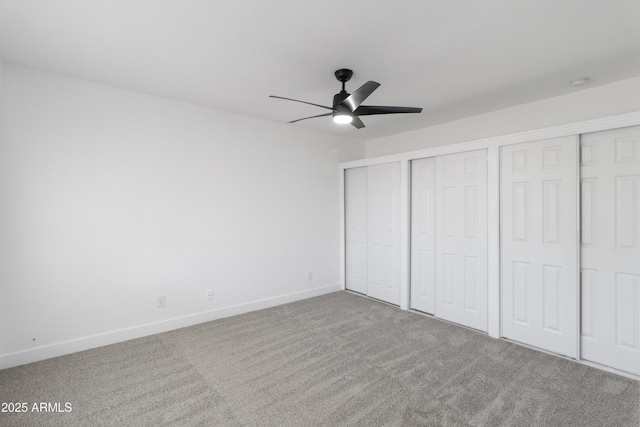 unfurnished bedroom featuring multiple closets, ceiling fan, and carpet flooring