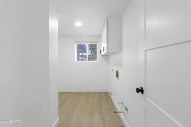 washroom with cabinets, washer hookup, hookup for an electric dryer, and light wood-type flooring