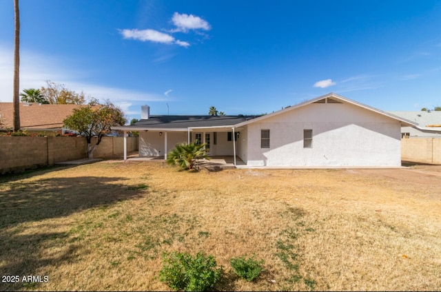 rear view of house with a yard and a patio area