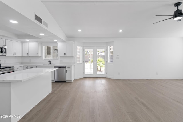 kitchen featuring appliances with stainless steel finishes, sink, light hardwood / wood-style flooring, white cabinets, and french doors