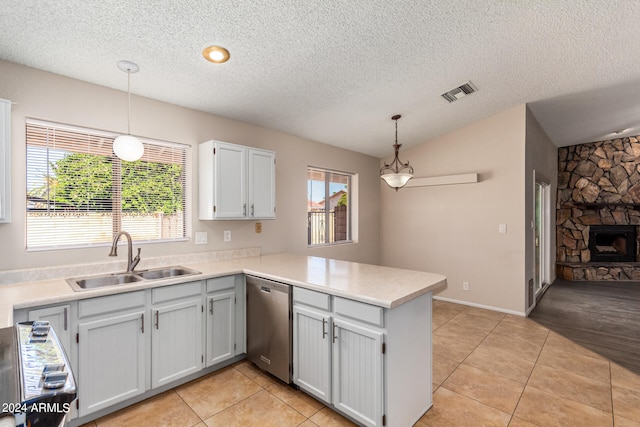 kitchen with decorative light fixtures, a fireplace, kitchen peninsula, and stainless steel appliances