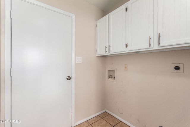 washroom with washer hookup, light tile patterned floors, hookup for an electric dryer, gas dryer hookup, and cabinets