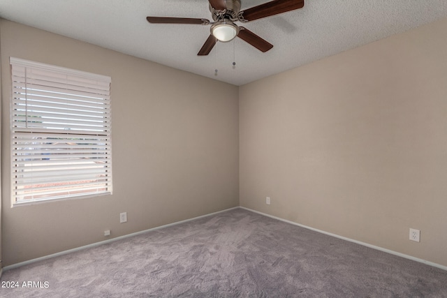 carpeted spare room featuring a textured ceiling and ceiling fan