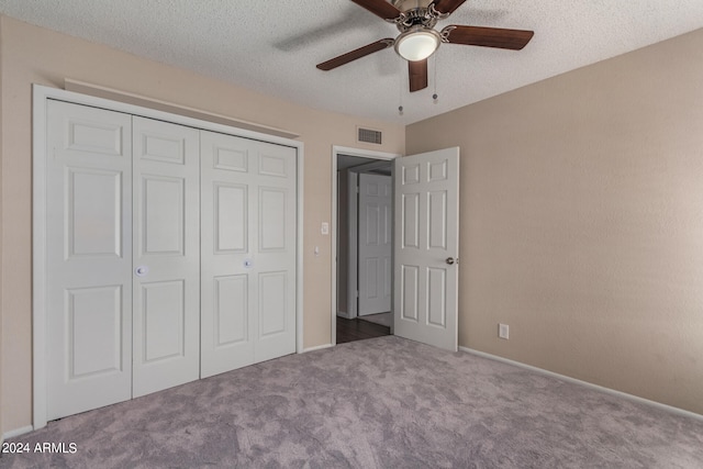 unfurnished bedroom featuring a closet, ceiling fan, carpet flooring, and a textured ceiling