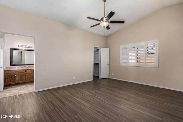 unfurnished living room with a textured ceiling, dark hardwood / wood-style floors, ceiling fan, and high vaulted ceiling