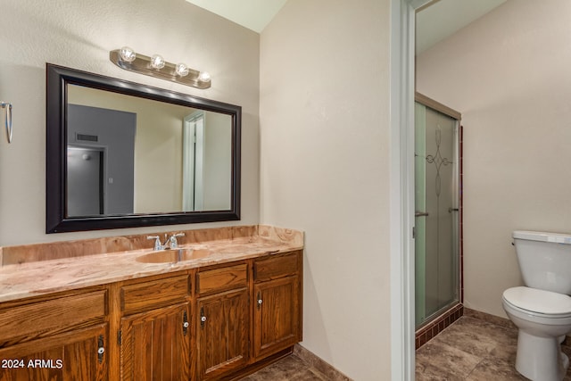 bathroom with a shower with shower door, vanity, and toilet