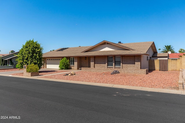 6034 E Hillview St, Mesa, AZ 85205 - single story home featuring driveway, fence, an attached garage, brick siding, and a shingled roof