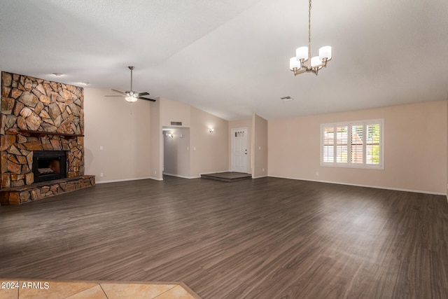 unfurnished living room featuring ceiling fan with notable chandelier, dark wood-type flooring, vaulted ceiling, and a fireplace