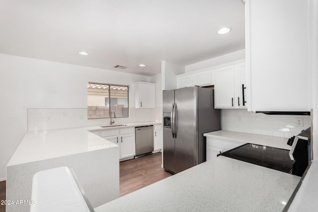 kitchen with decorative backsplash, appliances with stainless steel finishes, dark wood-type flooring, sink, and white cabinets