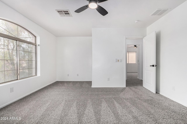 carpeted empty room featuring plenty of natural light and ceiling fan