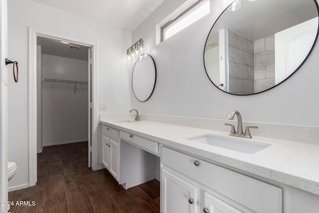 bathroom with toilet, vanity, and hardwood / wood-style flooring