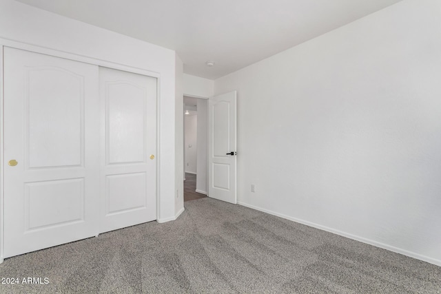 unfurnished bedroom featuring carpet and a closet